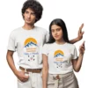 A couple is wearing matching white t-shirts. The t-shirts are personalized with the text "ADVENTURE TOGETHER", a mountain and sun graphic, and the names "Vishu & Bindu". The man is on the left and the woman is on the right, both looking at the camera. The design features crossed arrows and a small red heart.
