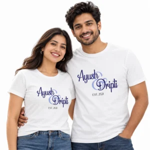 Indian couple wearing matching white personalized T-shirts with Ayush and Dripti names in blue decorative calligraphy and Est 2021 underneath.