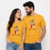 Couple wearing matching yellow personalized wedding caricature T-shirts with custom bride and groom names printed on the front.