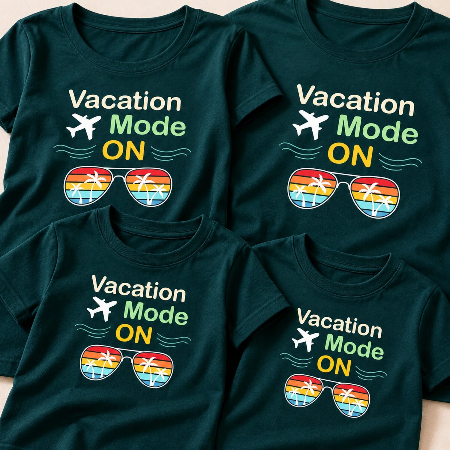 Close-up of four dark teal family vacation T-shirts showing the “Vacation Mode ON” airplane and tropical sunglasses design.
