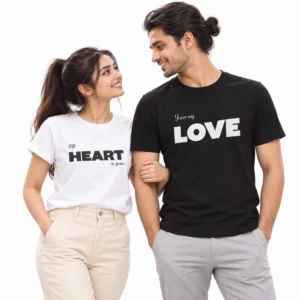 Indian couple wearing matching love-themed T-shirts, featuring My Heart Is Yours in black typography on a women's white T-shirt and You're My Love in white typography on a men's black T-shirt.