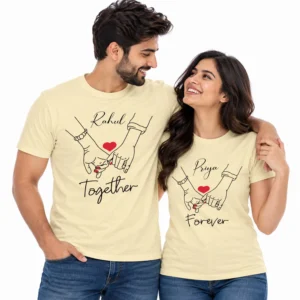Couple wearing personalized pale yellow matching T-shirts with Rahul and Priya names, holding-hands line art, red hearts, and Together Forever text.