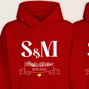 Close-up of red couple hoodie with S & M initials and EST.2025 floral ribbon design