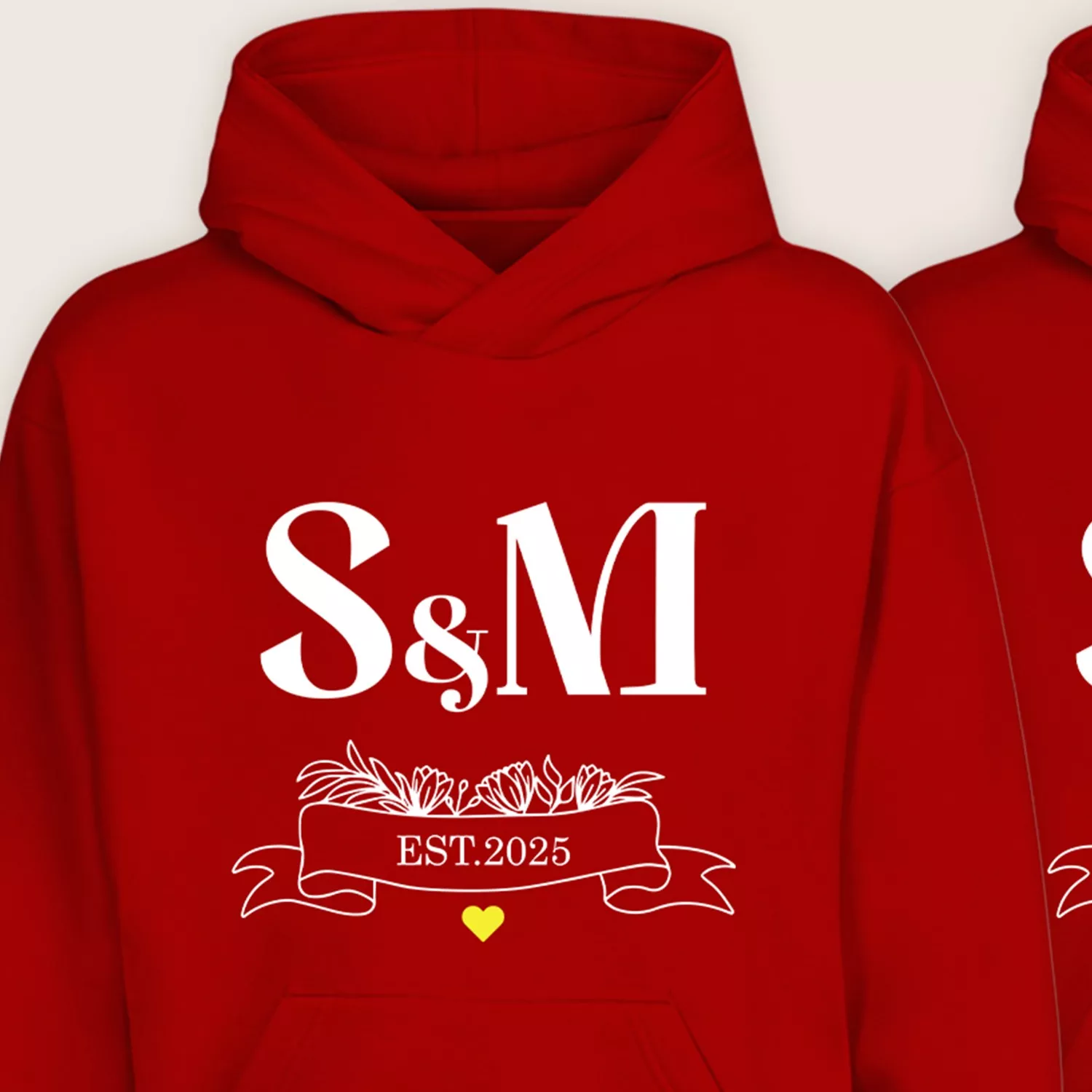 Close-up of red couple hoodie with S & M initials and EST.2025 floral ribbon design
