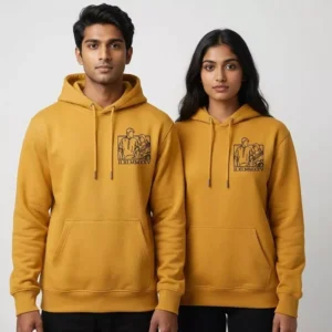 Couple wearing matching mustard hoodies with personalized line-art photo embroidery on the chest