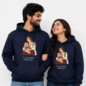 Couple wearing matching navy hoodies with a custom illustrated couple portrait design and “I’m incomplete without you!” text, shown as personalized anniversary gift sweatshirts.