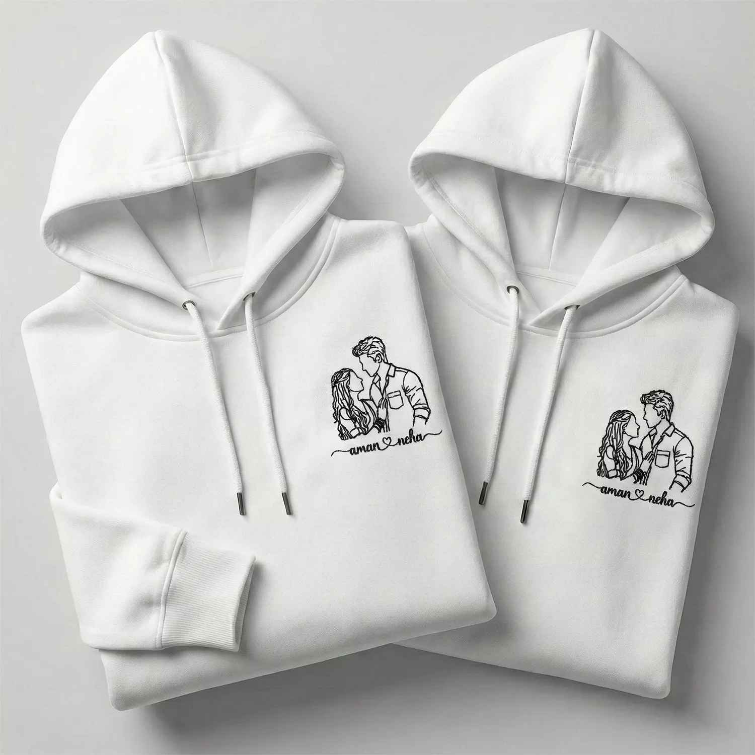 Custom line art embroidered couple hoodies with personalized portrait and names on white cotton hoodies