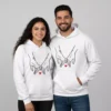 Couple wearing custom name initial couple hoodies with matching hand-holding design and heart illustration