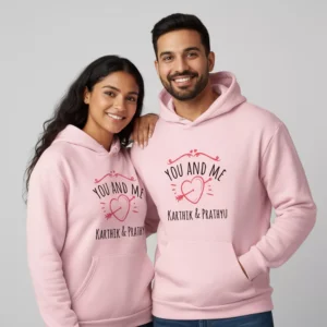 Couple wearing matching pink custom name printed hoodie pair with heart design, personalized hoodie pair gift