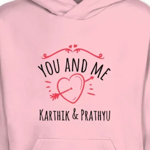 Close-up of pink couple hoodie with “You and Me” heart design and custom printed names