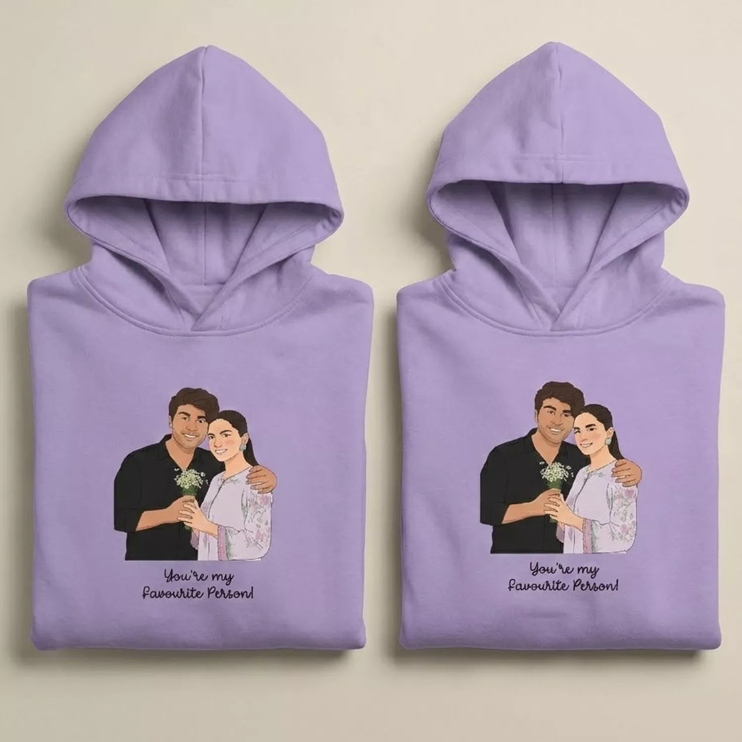 Folded lavender couple hoodies with custom vector portrait artwork and “You’re my favourite person” design