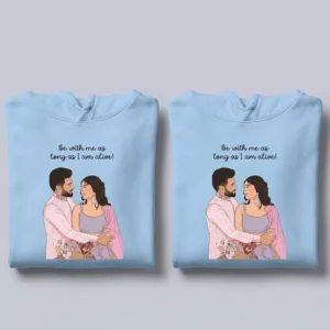 Folded personalized vector-art couple hoodies in light blue with custom illustrated portrait design