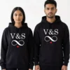 Personalized his and her initials couple hoodies in black with infinity design and red heart, worn by a couple