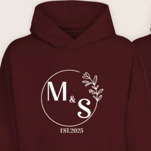 Close-up of maroon couple hoodie with personalized M & S initials and EST.2025 print