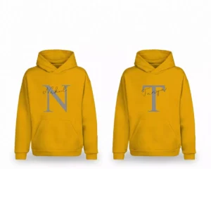 A matching couple hoodie set in yellow, featuring one hoodie with a grey 'N' and 'Nakul' and the other with a grey 'T' and 'Tanya'.