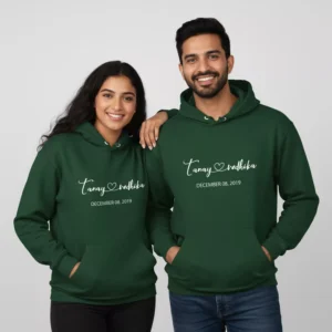 A couple wearing matching green custom matching couple name hoodies and date printed on the front.