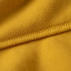 A macro shot of the yellow matching hoodie fabric, showing the soft natural weave and a line of durable stitching.