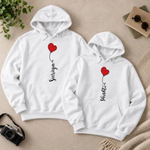 Two white personalized couple hoodies displayed flat with custom name prints and red heart balloon designs on a neutral background.