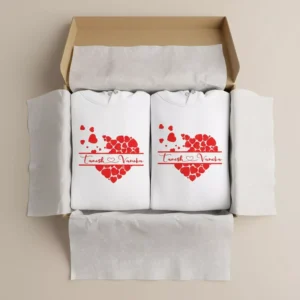 Two white personalized couple hoodies with red heart name print neatly packed inside a gift box.