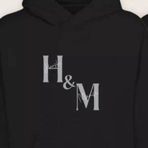 Close-up view of personalized couple hoodie with custom initials H and M printed in minimalist typography