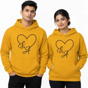Mustard yellow personalized couple hoodies with a black heart outline and elegant script S and A initials.