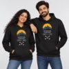 Black personalized couple hoodies with blue mountain and yellow sun graphics, Adventure Together text, and Daksh and Ishita names.