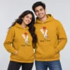 Mustard yellow personalized couple hoodies with holding-hands artwork, Chinmay and Aarushi names, a red heart, and Always & Forever text.