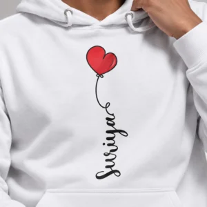 Close-up of a white personalized hoodie featuring a red heart balloon graphic and vertical custom name print on the front.
