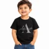 Smiling toddler boy wearing a black personalized kids T-shirt featuring a large gray letter A with the name Aarush written across it in elegant light-colored cursive lettering.