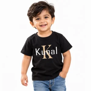 Smiling toddler boy wearing a black personalized kids T-shirt featuring a large gold letter K monogram with the custom name Kunal in white lettering.