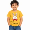 Smiling little boy wearing a yellow personalized kids T-shirt featuring a white cartoon bunny rabbit with pink ears, a red bow tie, and the name Sameer in black cursive lettering.