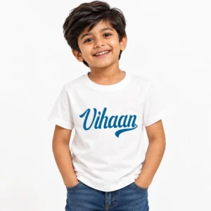 Smiling young boy wearing a white personalized kids T-shirt featuring the name Vihaan in large blue cursive lettering with a decorative underline.