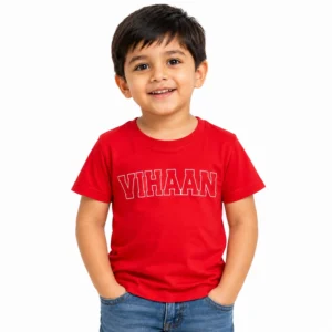 Smiling young boy wearing a red personalized kids T-shirt featuring the name VIHAAN in bold white outlined varsity-style lettering across the chest.