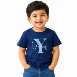 Smiling toddler boy wearing a navy blue personalized kids T-shirt featuring a large light blue letter Y with the name Yusuf written across it in white cursive script.
