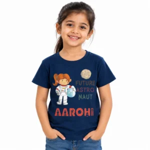 Smiling young girl wearing a navy blue personalized T-shirt featuring a cartoon girl astronaut, moon, colorful Future Astronaut lettering, and the name Aarohi in bold coral-red letters.