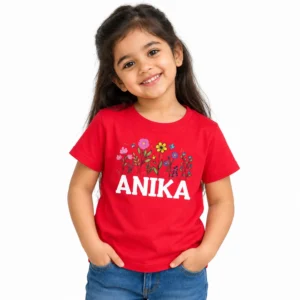 Smiling young girl wearing a red personalized kids T-shirt with colorful pink, yellow and purple flowers above the name ANIKA in bold white uppercase letters.