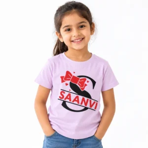 Smiling young girl wearing a light lavender personalized T-shirt featuring a large black letter S, red bow, small red hearts and the name SAANVI in bold red letters.