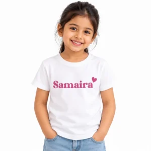 Smiling young girl wearing a white personalized kids T-shirt featuring the name Samaira in bold pink lettering with a matching pink heart.