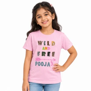 Young girl wearing a light pink personalized kids T-shirt featuring WILD AND FREE lettering with animal-print patterns, a pink arrow graphic, and custom name POOJA.