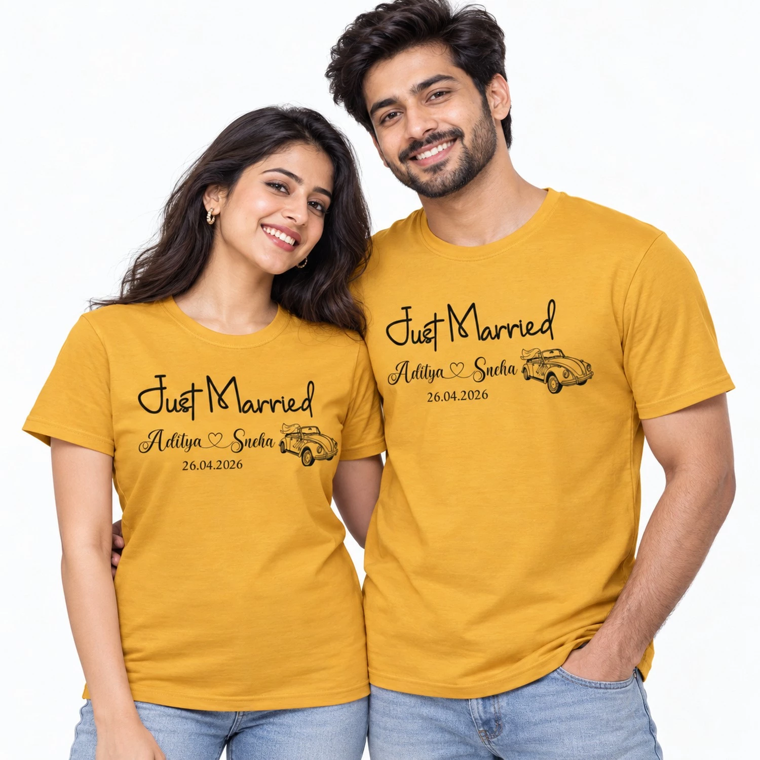 Couple wearing matching mustard yellow Just Married T-shirts with Aditya and Sneha names, wedding date 26.04.2026 and a vintage wedding car illustration.