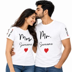 Indian couple wearing matching white personalized Mr. and Mrs. T-shirts featuring custom surname text, red hearts, and EST. Year sleeve prints.