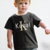 Child wearing black personalized cotton T shirt with custom name and large initial print