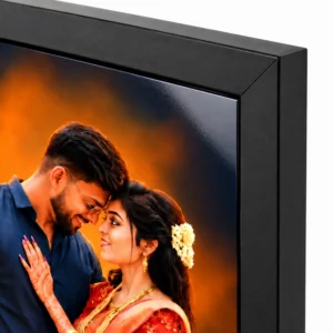 Close-up of a black personalised couple photo frame showing the glossy portrait surface, frame corner and wedding couple artwork.