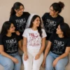 Bride and friends wearing personalised hen party T-shirts with Team Bride designs, cocktail graphics and party names