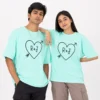Couple wearing matching mint oversized T-shirts with personalised R and J initials inside a heart and arrow design