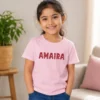 Personalised pink girls T-shirt with Avaira name in decorative red lettering