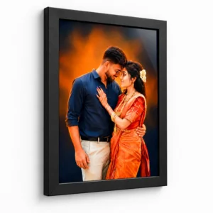 Angled wall view of a personalised couple photo frame with a black frame and romantic wedding portrait in orange and navy tones.