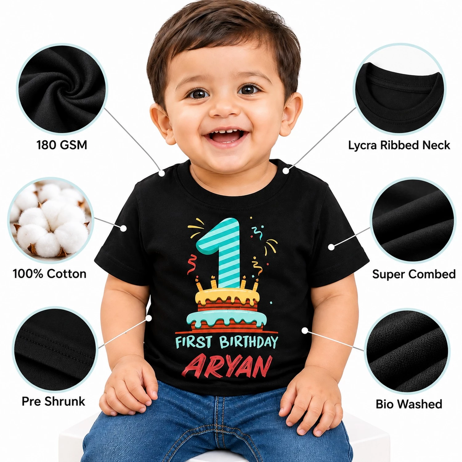 Smiling toddler wearing a black personalized 1st birthday kids t-shirt with visible quality callouts including 180 GSM, 100% cotton, super combed, pre shrunk, bio washed, and lycra ribbed neck.