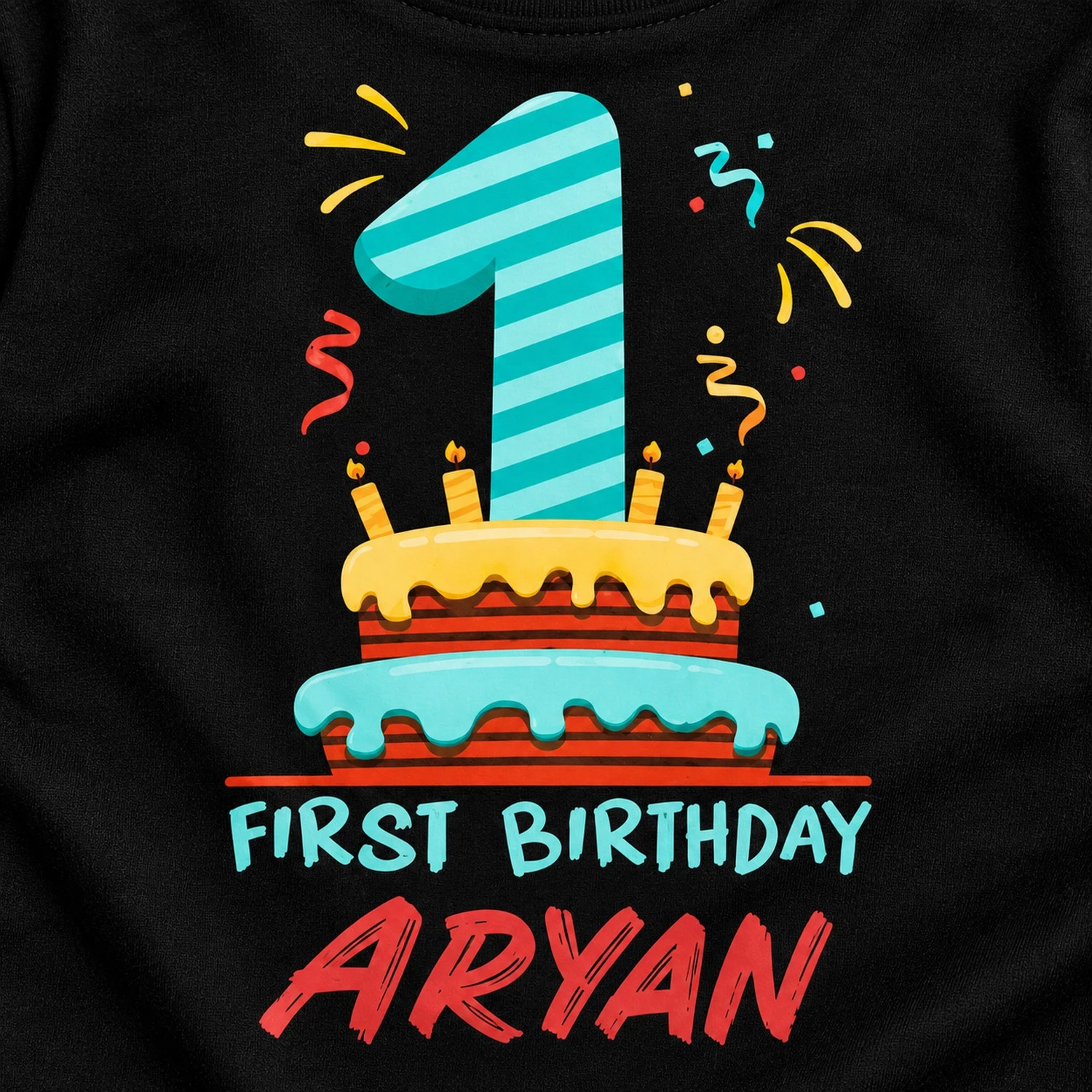 Close-up detail of a personalized 1st birthday t-shirt print showing a number 1 cake design, First Birthday text, and the name Aryan on black fabric.