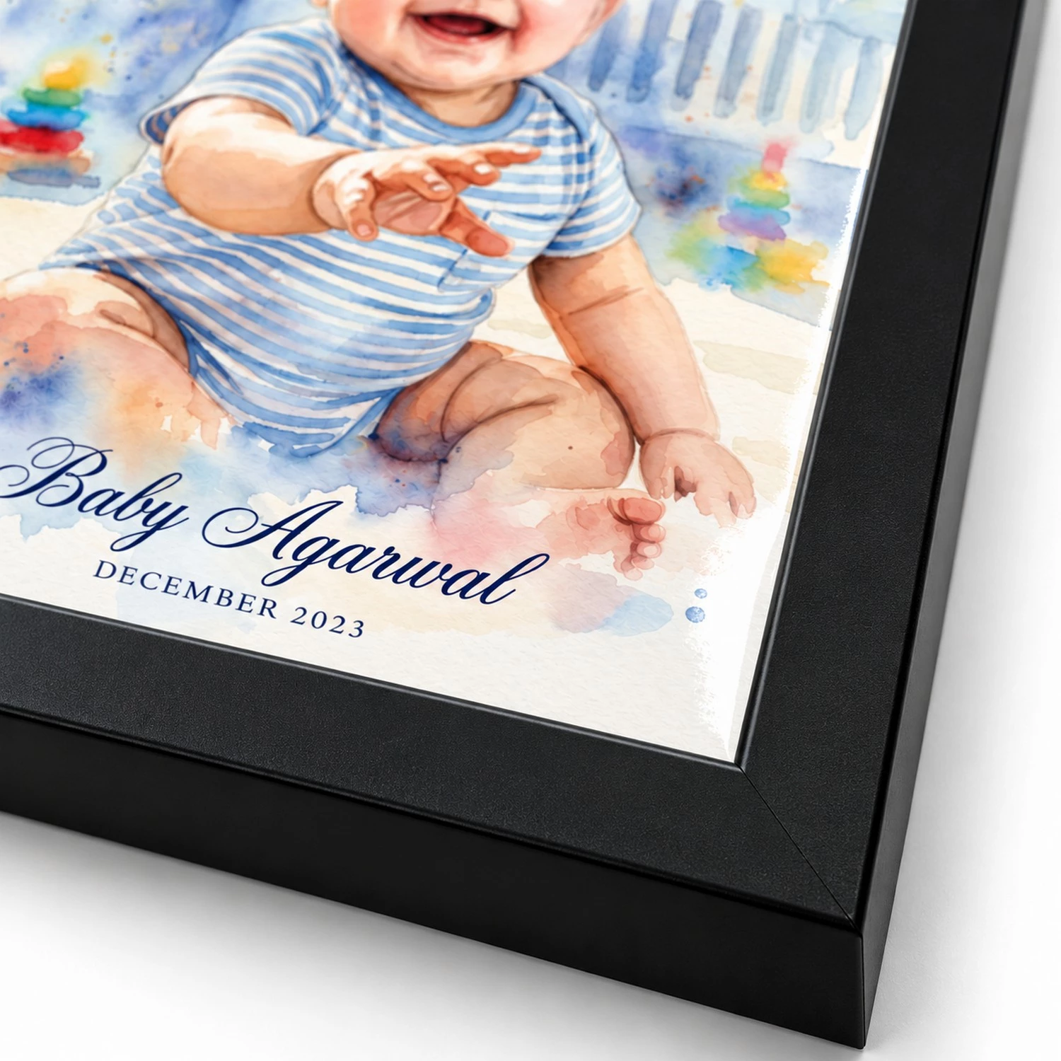 Close-up of the black frame corner and edge of a personalized watercolor baby portrait with custom name and date.